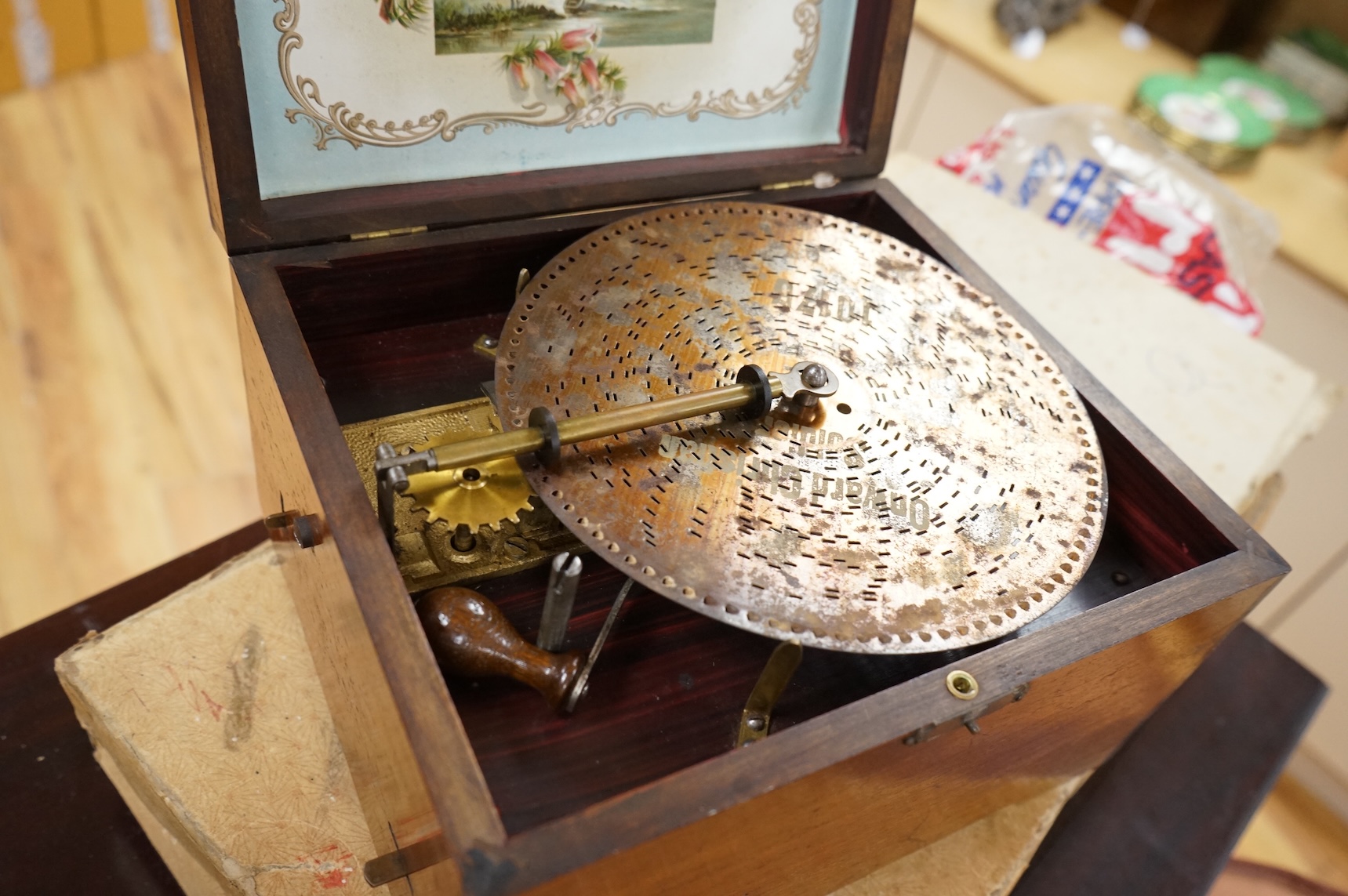 A late 19th century Monopol disc music box in a mahogany case, to play discs 19cm diameter, together with twelve discs, plus an ebonised ‘Chord-Harps’ zither in its original card box with tuning hammer.